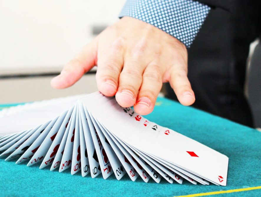 A person is playing with cards on the table