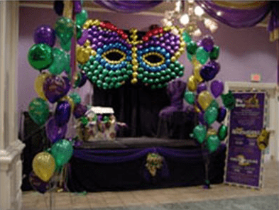 A room decorated with balloons and purple curtains.