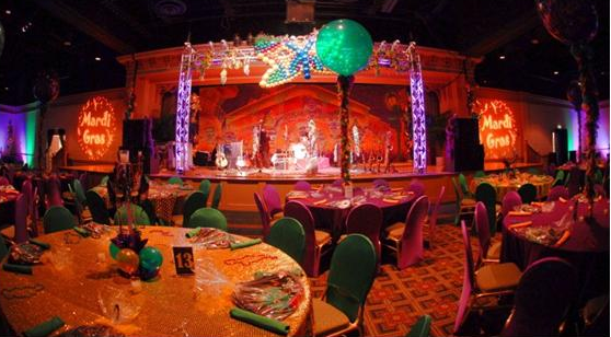 A room with tables and chairs, balloons and lights.