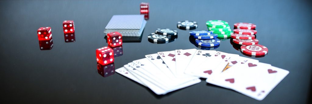 A table with cards, dice and chips on it.