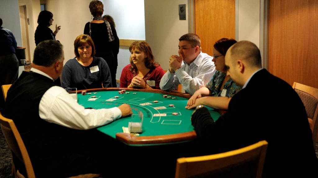 A group of people sitting around a table playing poker.